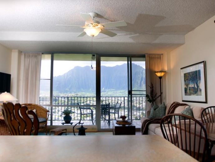 Spacious apartment living room and view of the mountains outside the sliding glass door at Good Samaritan Society - Pohai Nani in Kaneohe, Hawaii.