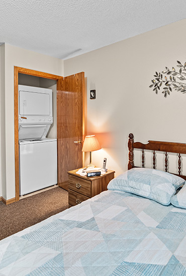 Independent living apartment bedroom with washer and dryer at Good Samaritan Society - Waukon.