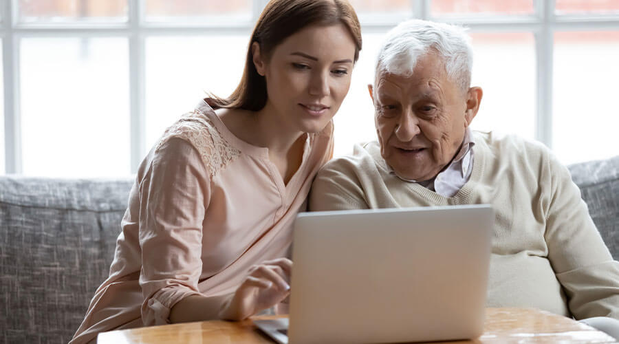 Adult woman and her father looking at a computer.