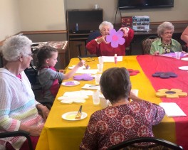Residents create paper flowering during a craft class